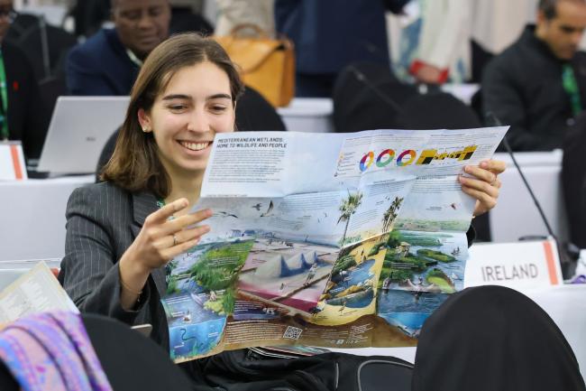 A delegate reads a brochure about Mediterranean Wetlands 