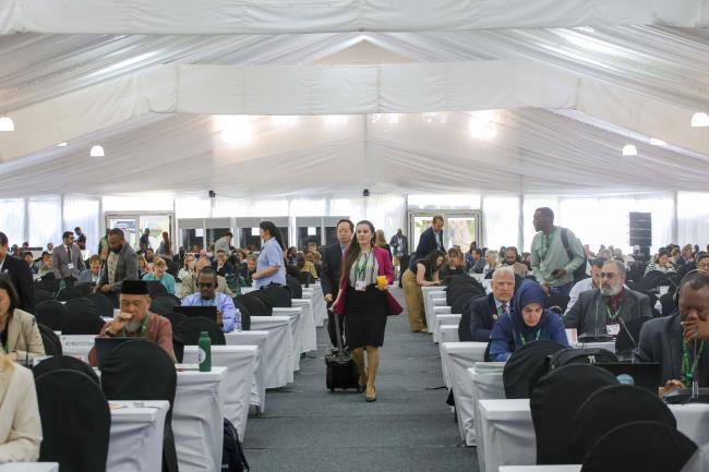 Delegates walk into the plenary room for the morning session. 