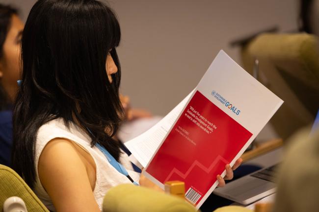 A delegate reads the latest SDG Progress Report