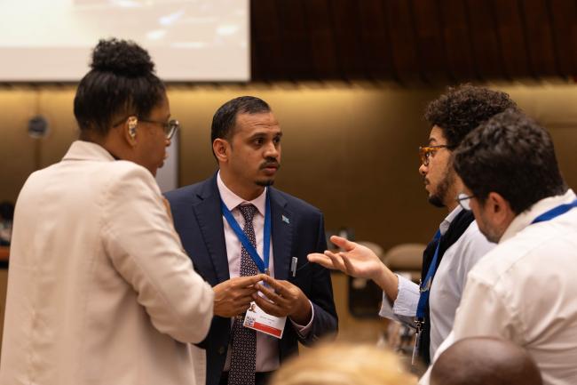 Delegates from Grenada, Fiji, and Brazil consult