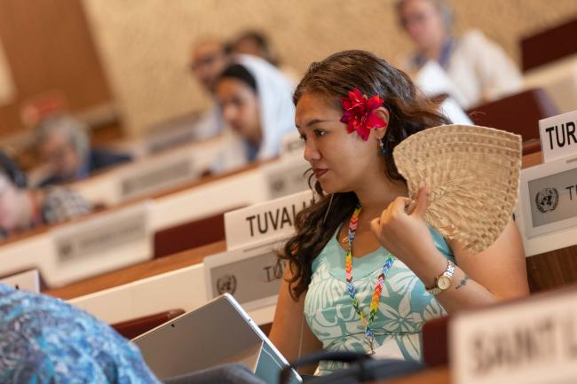 Delegates listen to the discussions in the contact groups