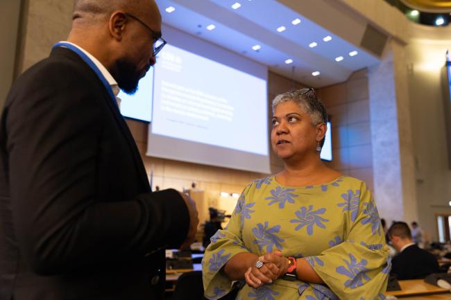 Ailis Rego, INC Secretariat, consults with a delegate