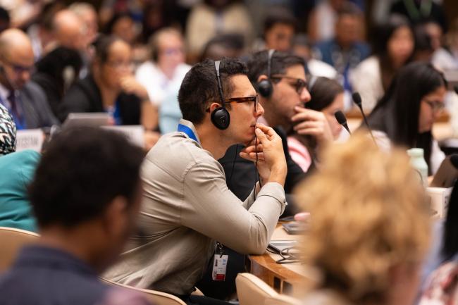 Delegates listen to discussions in contact groups throughout the day
