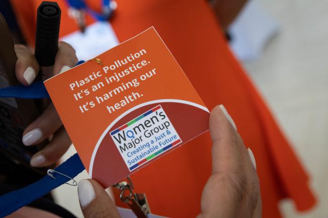 Representatives of the Women’s Major Group wear orange clothing to highlight the impact that plastics have on human health, as the topic comes under discussion in the contact groups