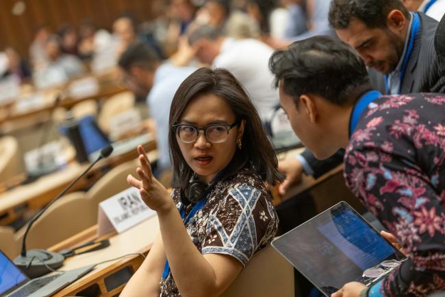 Delegates consult during the session
