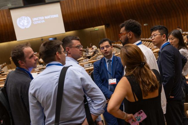 Delegates huddle informally before the start of the session