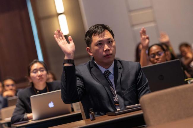 Participants raise their hands to show their involvement in local, national, and international policy processes