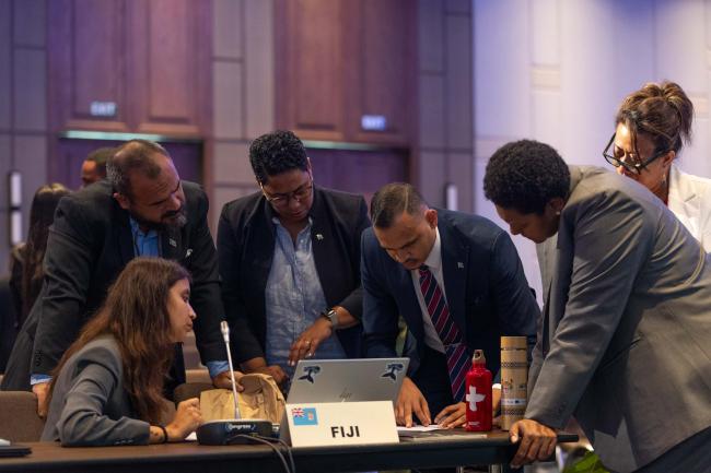 Delegates from Fiji consult at the start of the day