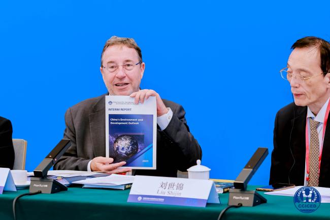 CCICED Vice Chairperson and former Administrator, UNDP, holding up the CCICED Interim Report %22China's Environment and Development Outlook%22_ cciced2025_16Okt25