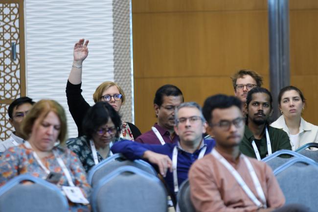 A participant raises their hand to make a comment. 
