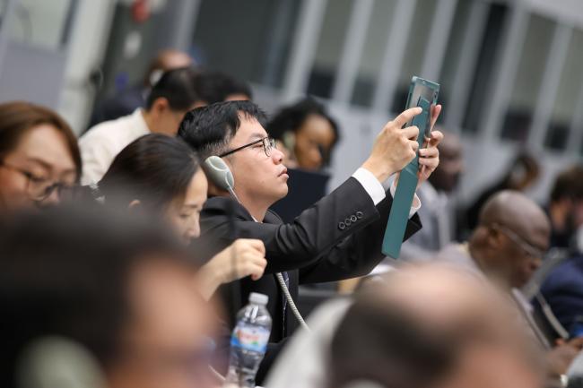 Delegates take pictures of the slides 