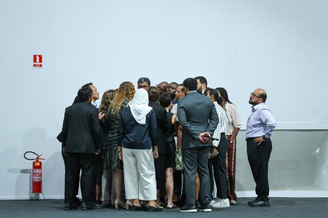 Participants forming a huddle during informal consultations on national adaptation plans 