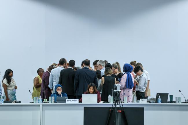 Delegates forming a huddle during informal negotiations