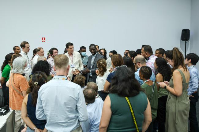 Participants forming a huddle during an informal consultation on capacity-building