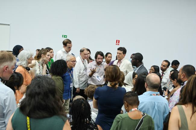 Participants forming a huddle during an informal consultation on capacity-building