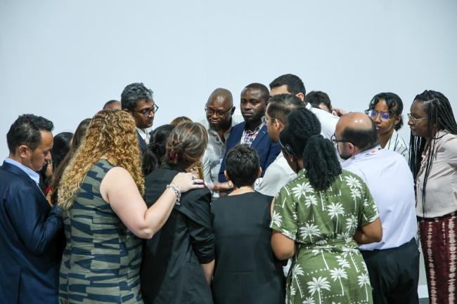 Participants forming a huddle during informal consultations on national adaptation plans 