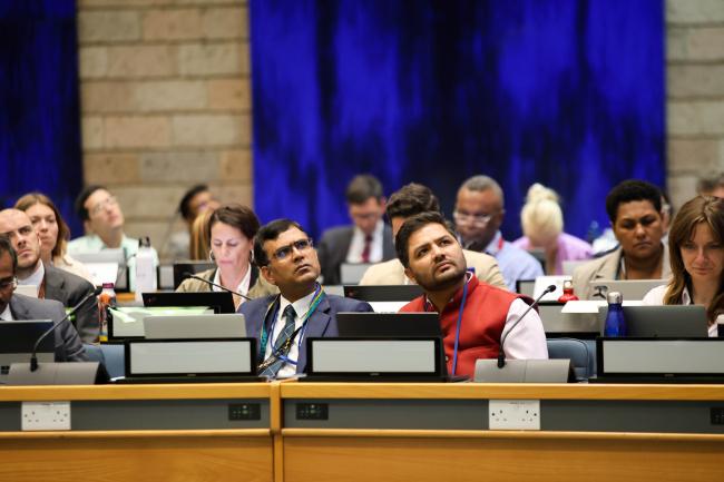 Delegates look the text at the screen 