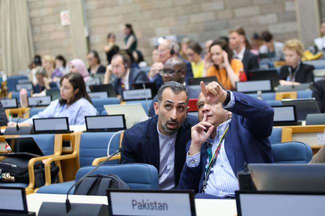 Delegates from Iran and Pakistan consult. 