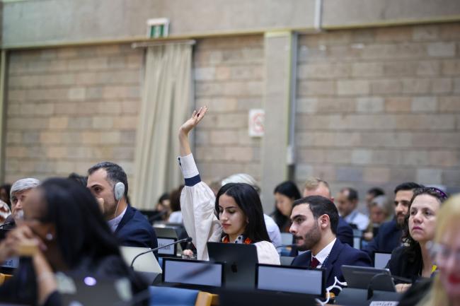 A delegate raises her hand to speak.