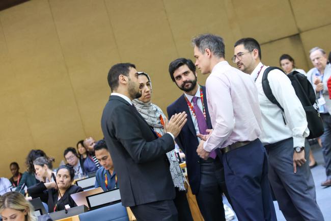 Delegates consult during the session. 