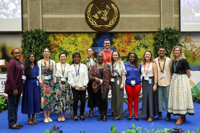 UNEP Secretariat screen editors responsible for live text capture during negotiations pose for group photo.  