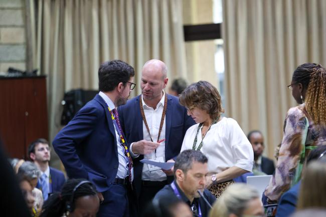 Delegates consult during the closing plenary 
