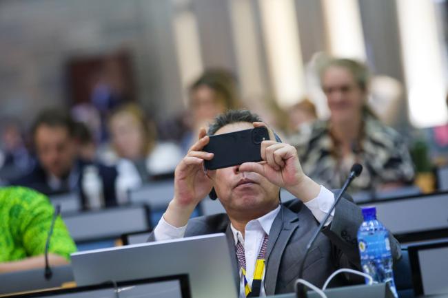 A delegate takes a picture.