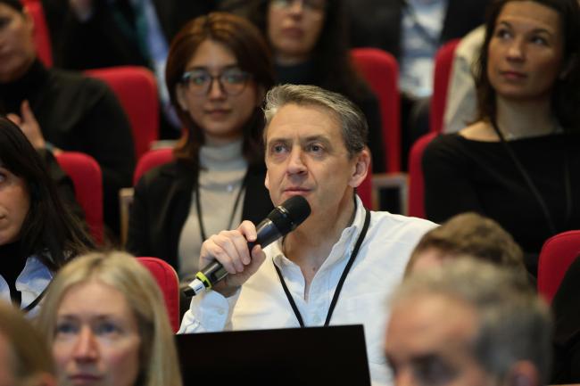 Participants take the floor to pose questions to the panel.