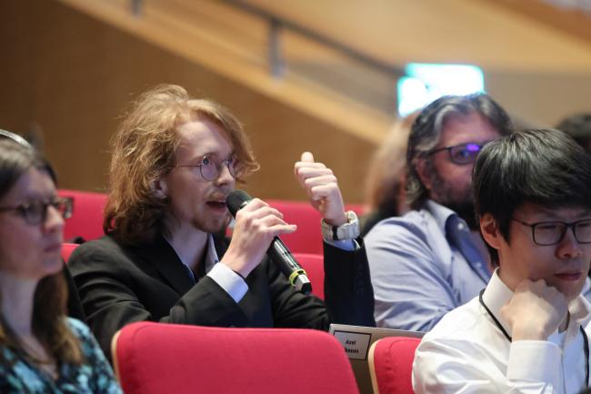 Participants take the floor to pose questions to the panel. 