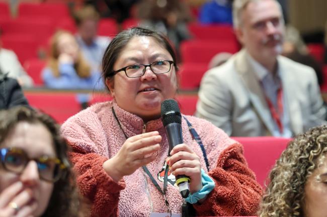 A participant poses a question to the panelists. 
