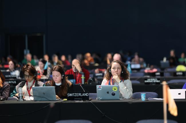 Delegates listen to the negotiations.