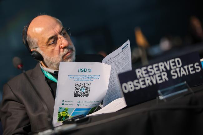 A delegate reads the ENB daily report. 