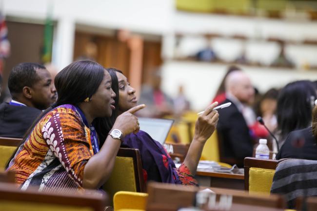 Delegates discuss the text on the screen. 