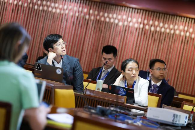 Delegates from China looking at the text on the screen 