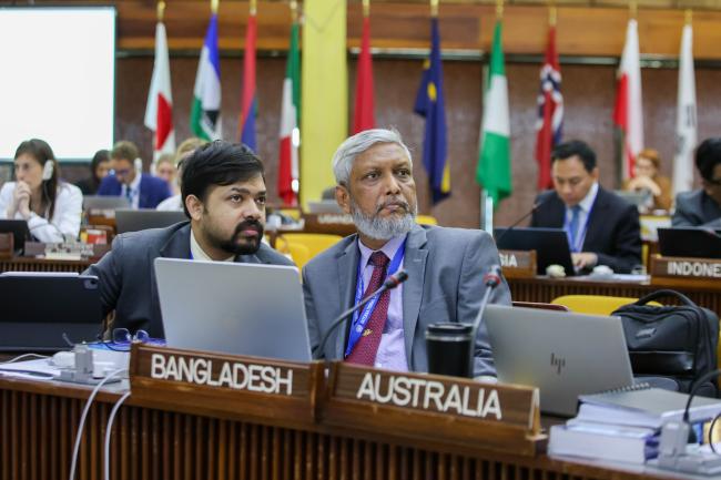 Delegates from Bangladesh looking on the text changes on the screen