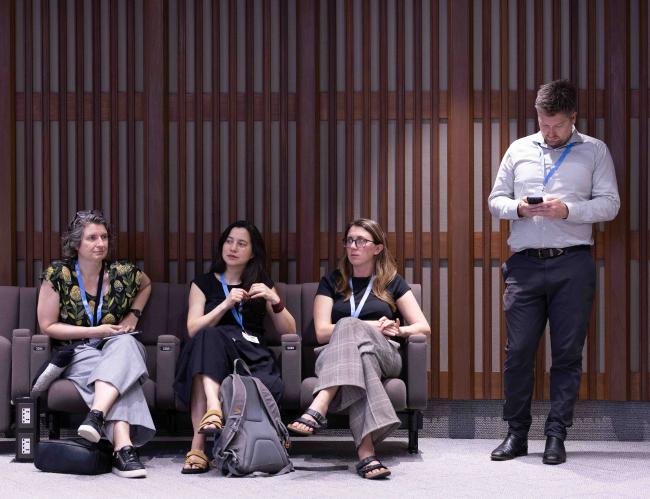 Delegates observe the discussions from the back of the room. 