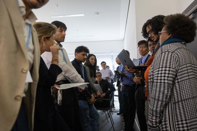Delegates huddle during the informal consultations on matters relating to capacity-building