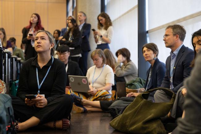 Delegates sit on the floor as the room is filled to capacity
