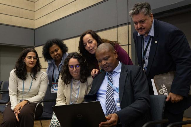 Members of the UNFCCC Secretariat consult during the informal consultations on the adaptation communications