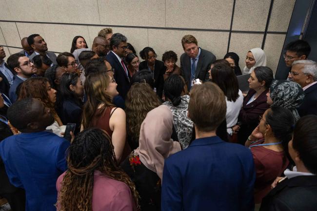 Delegates huddle during the informal consultations on the Global Goal for Adaptation (GGA)