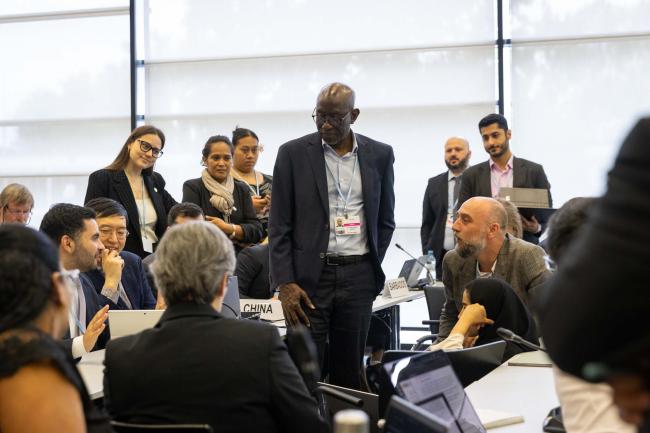 Delegates huddle during the informal consultations on Art 6.8 (non-market approaches)