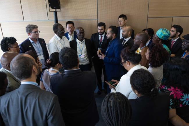 Delegates huddle during the informal consultation on the Climate Technology Centre (CTC)