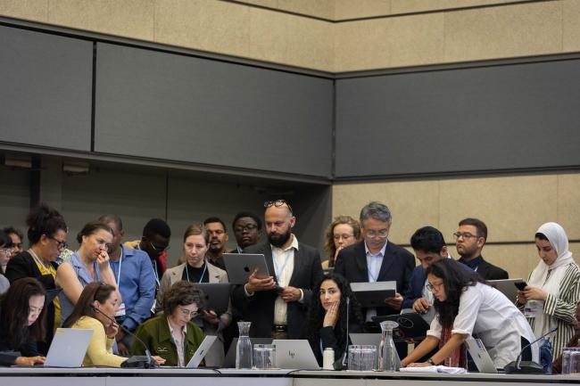 Delegates huddle during the informal consultations on research and systematic observation