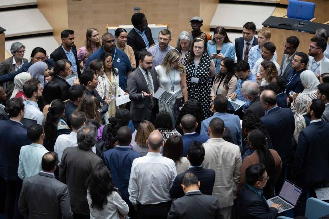 Delegates huddle during the informal consultations on the mitigation work programme