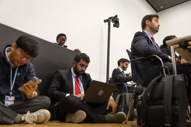 Delegates sit on the floor as the seats are full