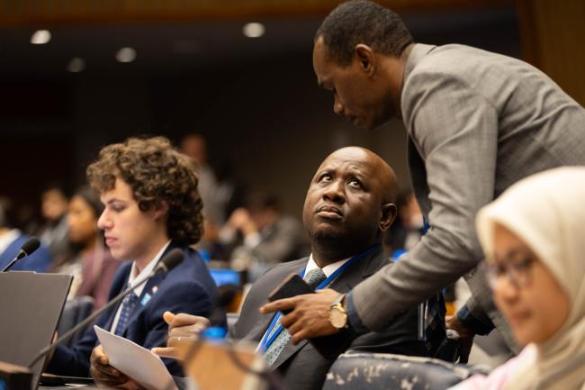 Delegates consult during the session